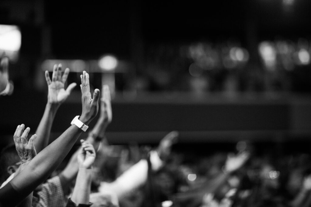 pexels photo 2014773 2014773 Black and white image of audience with hands raised, capturing concert energy.
