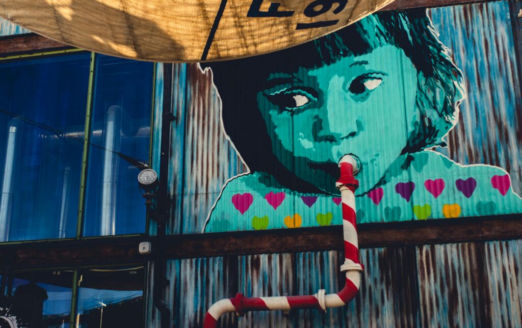 pexels photo 2103127 2103127 Colorful mural depicting a child with a pipe, showcasing vibrant street art in Dubai.